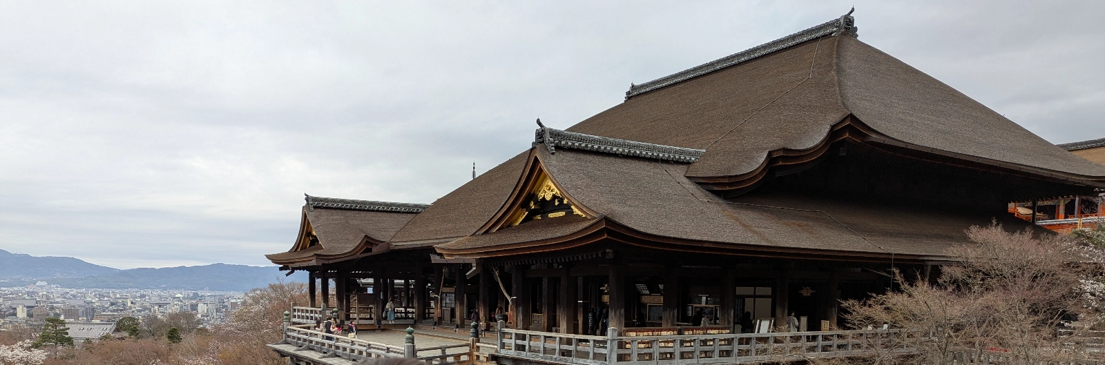 Kiyomizu-dera’s wooden stage overlooking the cherry tree-covered hillside of Kyoto, captured in early spring stillness.