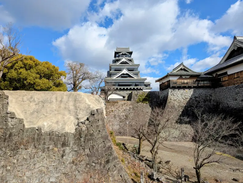Off the beaten path Kumamoto: Historical stone walls and the Kumamoto Castle keep, a symbol of Kumamoto’s strength and enduring history.