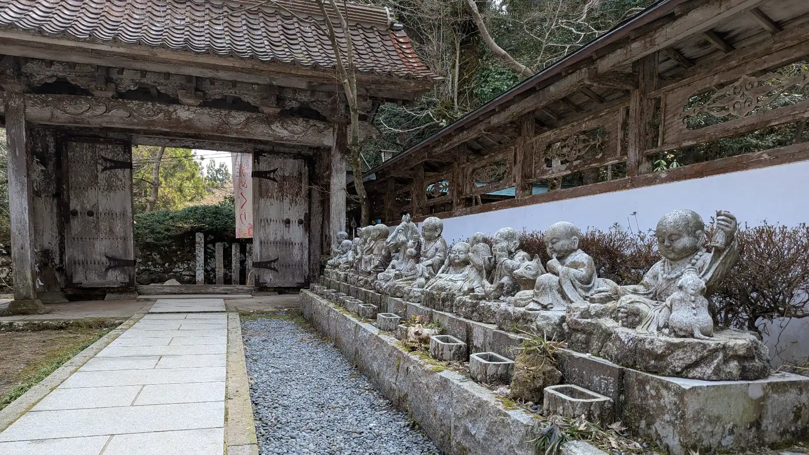 Stone Jizō statues lined up near the entrance gate of Sanbutsu-ji Temple in Tottori, Japan