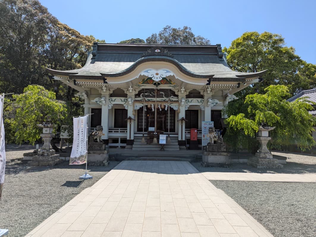 The main worship hall of Takeo Shrine in Saga, Japan, framed by lush greenery and peaceful grounds on a clear spring day.