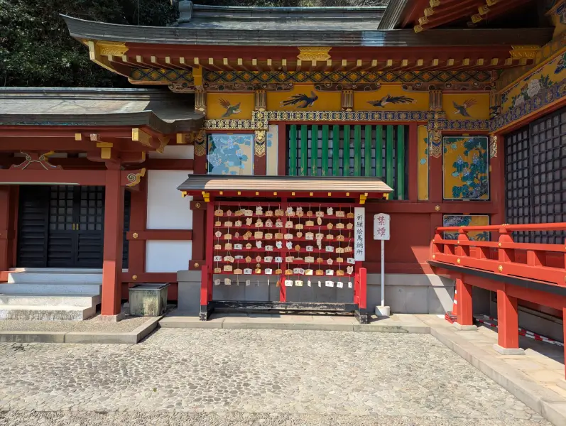 Vibrant ema prayer plaques displayed outside the richly decorated main hall at Yutoku Inari Shrine in Saga, Japan.